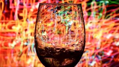 在五颜六色的背景下，将白葡萄酒从瓶子中缓慢地倒入杯中，葡萄酒的美丽库存镜头